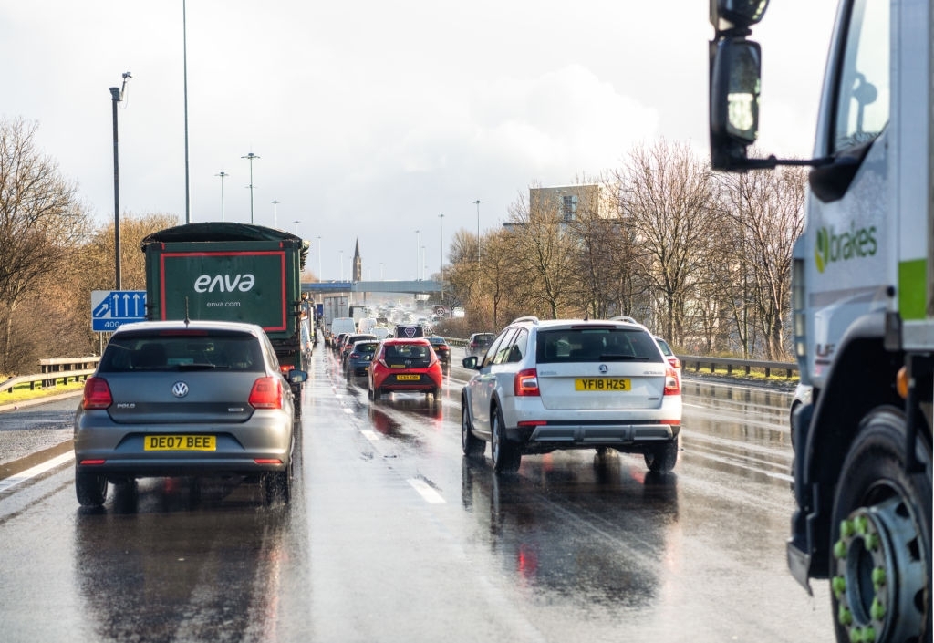 Glasgow, Scotland - A driver's point of view of the M8 motorway in Glasgow, with traffic congestion and surface water during a rain shower.
